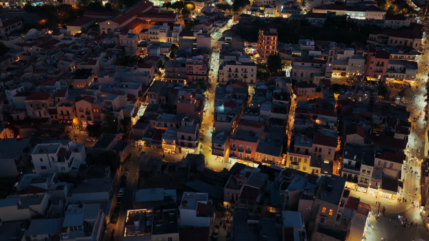 Aerial drone view of the old town rooftops around the covered market hall at night, Chania, Greece