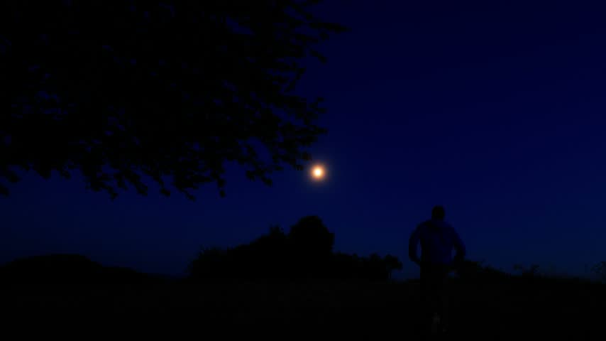 Moon on a twilight sky with landscape mountain silhouettes.