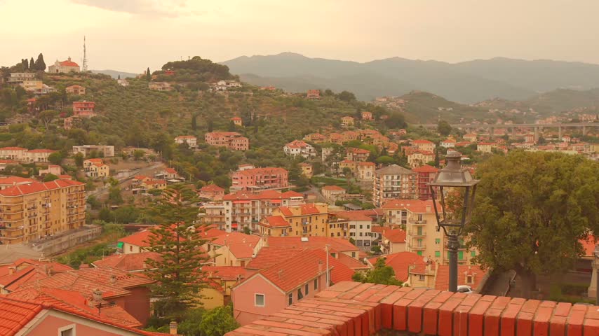 Wide view over Imperia rooftops and hills at sunset, Italian Riviera townscape