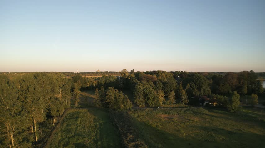 Water reservoir surrounded by green woodland in Belgium with soft natural lighting, panoramic view
