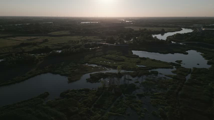 Swampy wetlands with ponds in Belgium at sunset, tranquil natural scene, aerial view