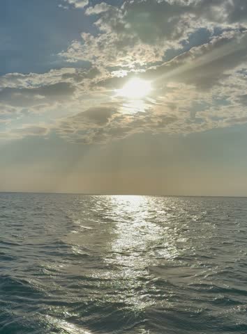 Small boat traveling across the Caribbean Sea near Santa Marta, Colombia, beneath a dramatic sunlit sky.