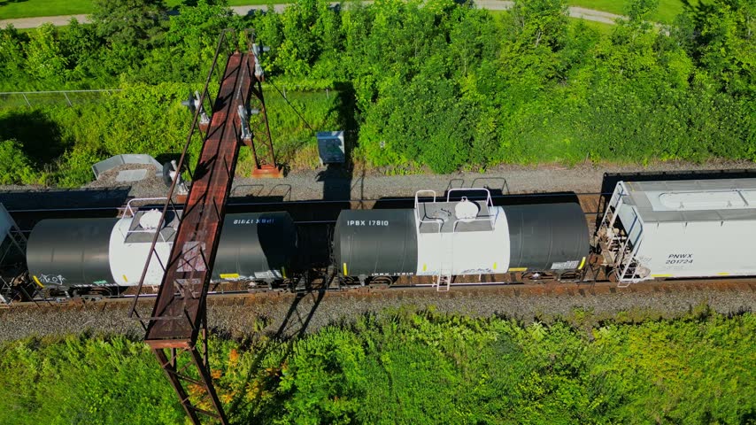 Industrial freight train carrying various goods on railroad tracks through Burlington, Ontario, Canada