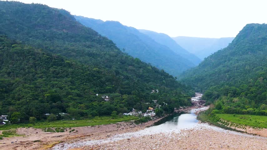 Scenic border landscape featuring hills and dry riverbed in winter season - aerial shot.