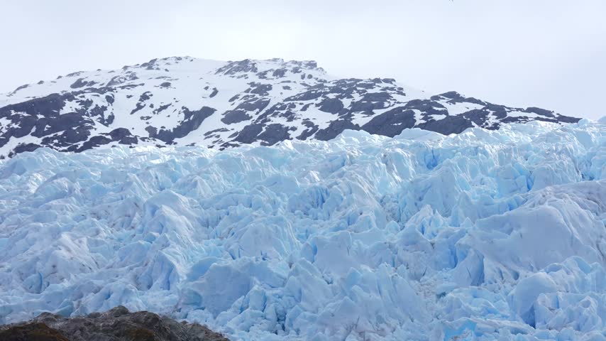 Blue Glacier Ice and Snow Capped Hills on Coast of Antarctica