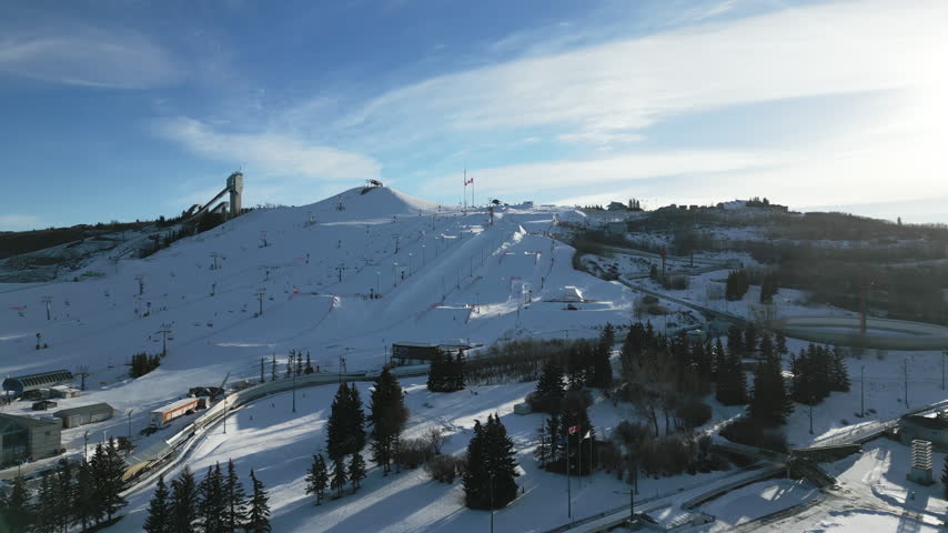 Establishing aerial view pushing in on ski hills on a clear sunny day in Calgary, Alberta