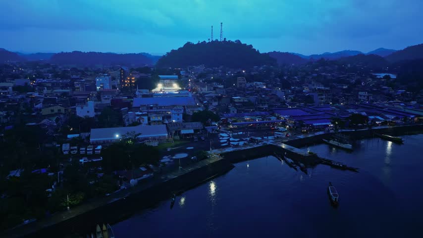 Cinematic aerial view of Buhi town and Lake Buhi during blue hour in Camarines Sur, Philippines. The footage features the urban and lakeside areas around San Benito, San Pascual and Santa Cruz, with M