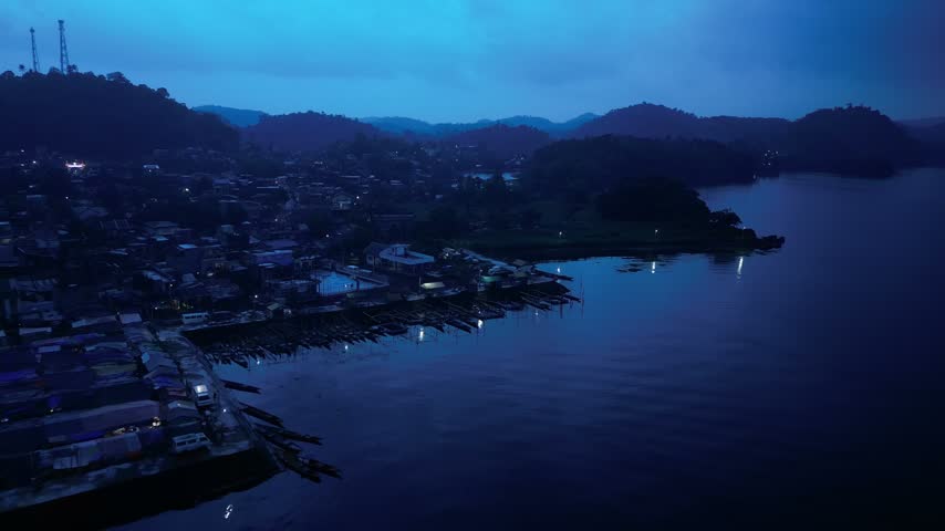 Aerial view over Buhi town and Lake Buhi at dusk in Camarines Sur, Philippines, with Mount Asog, also known as Mount Iriga, in the background. Santa Cruz barangay is visible in the distant landscape.