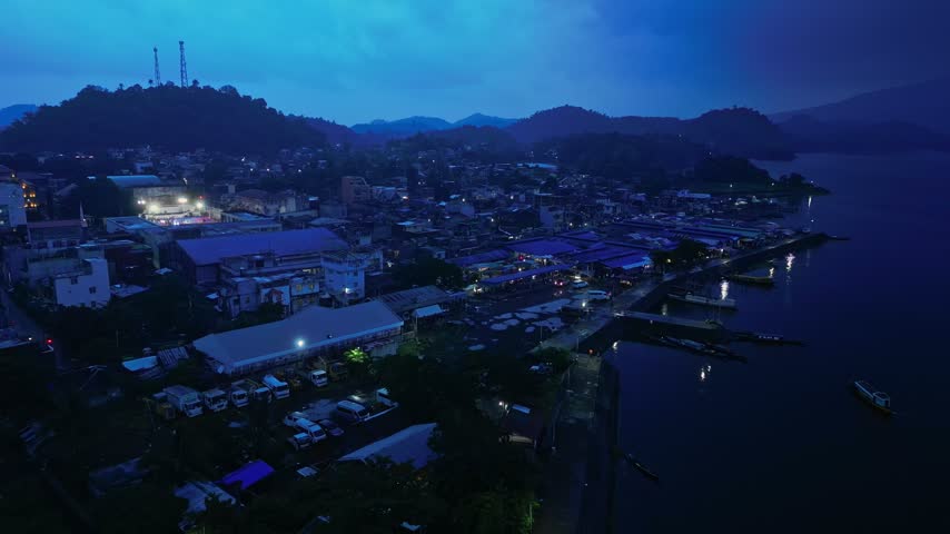 Cinematic aerial view of Buhi town and Lake Buhi during blue hour in Camarines Sur, Philippines. The footage features the urban and lakeside areas around San Benito, San Pascual and Santa Cruz, with M