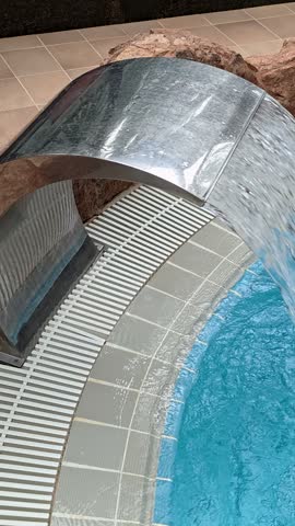 Pool with a waterfall and water feature, ideal for relaxing and serene environments.