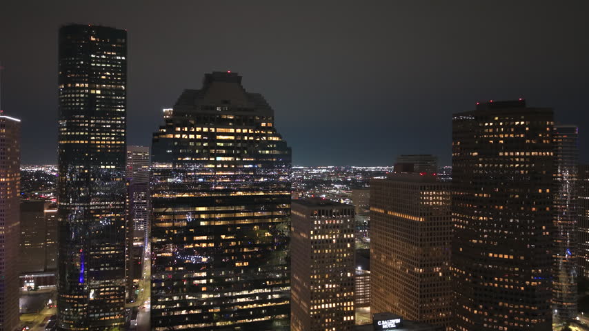 Aerial night view of Houston, Texas with dense commercial district and busy roadways. Modern illuminated buildings in city impressive skyline.