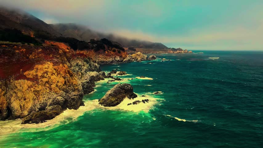 An aerial view captures the dramatic and rugged Pacific coastline of Big Sur along California