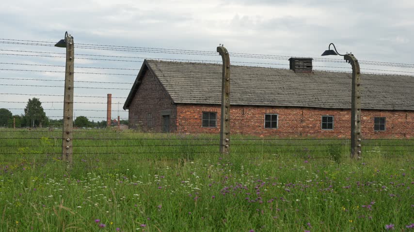 OSWIECIM, POLAND Historic main entrance gatehouse and wooden barracks at the Auschwitz II-Birkenau concentration camp