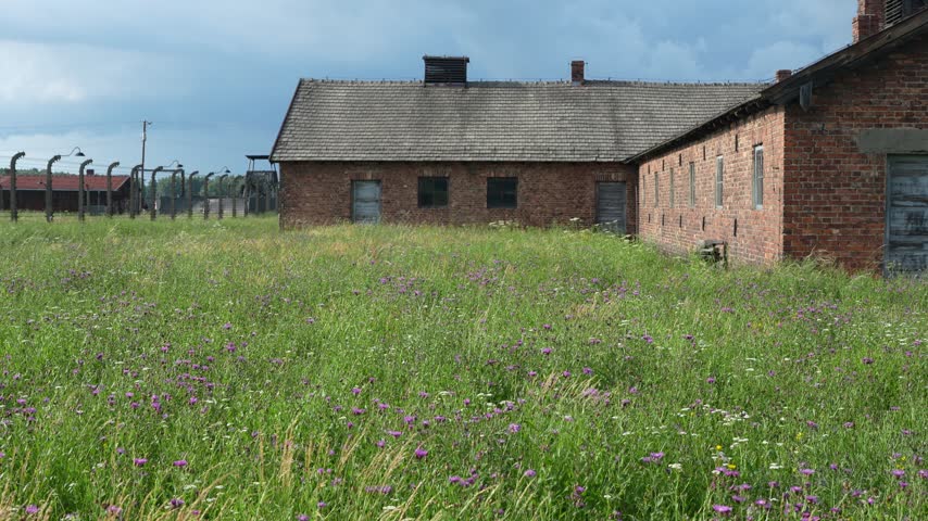 OSWIECIM, POLAND Historic main entrance gatehouse and wooden barracks at the Auschwitz II-Birkenau concentration camp