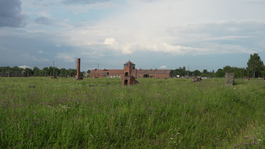 OSWIECIM, POLAND Historic main entrance gatehouse and wooden barracks at the Auschwitz II-Birkenau concentration camp
