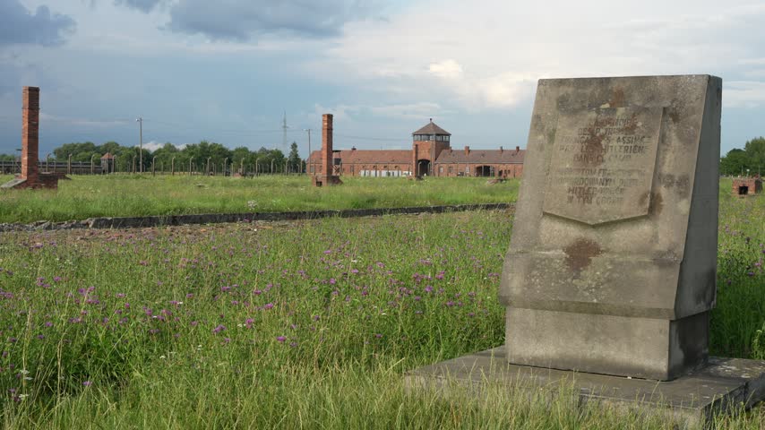 OSWIECIM, POLAND Historic main entrance gatehouse and wooden barracks at the Auschwitz II-Birkenau concentration camp