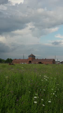 OSWIECIM, POLAND Historic main entrance gatehouse and wooden barracks at the Auschwitz II-Birkenau concentration camp