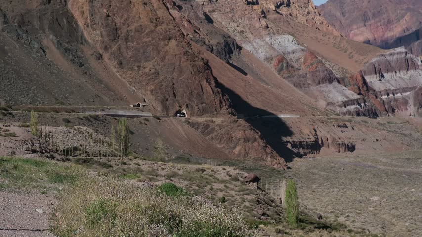 Breathtaking mountain landscape with colorful rock formations, road, and tunnels in Patagonia, Argentina. Perfect for travel and nature projects