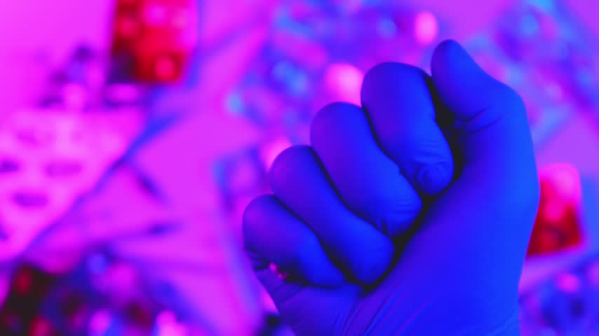 Scientist in blue gloves holding syringe with a vaccine in a research laboratory