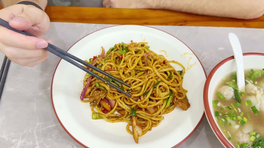 Chinese Restaurant Table with Noodles on Plate and Wonton Soup in Bowl – Traditional Dumplings and Noodle Dish	
