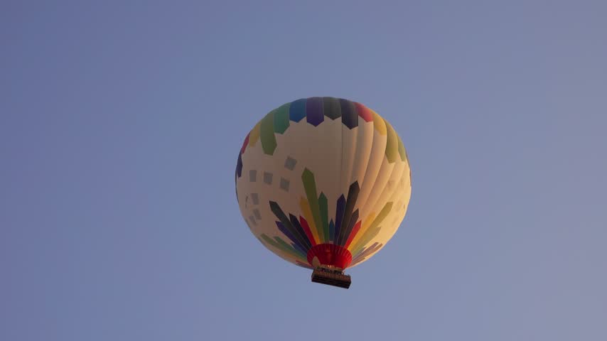 View of a colorful hot air balloon floating in the sky over the Luxor Governorate, Egypt.