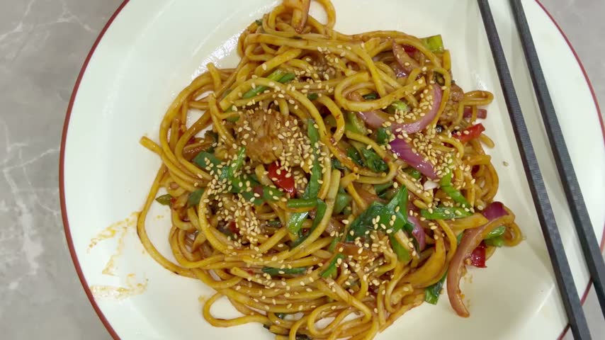 Chinese Restaurant Table with Noodles on Plate and Wonton Soup in Bowl – Traditional Dumplings and Noodle Dish	
