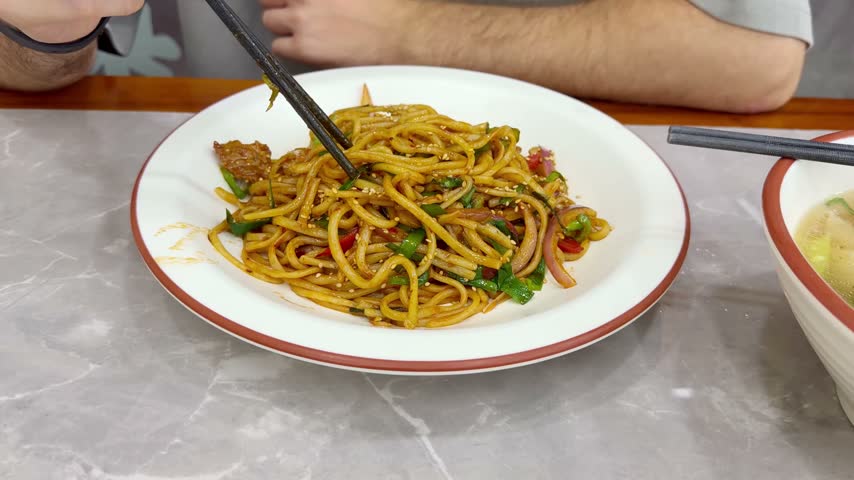 Chinese Restaurant Table with Noodles on Plate and Wonton Soup in Bowl – Traditional Dumplings and Noodle Dish	
