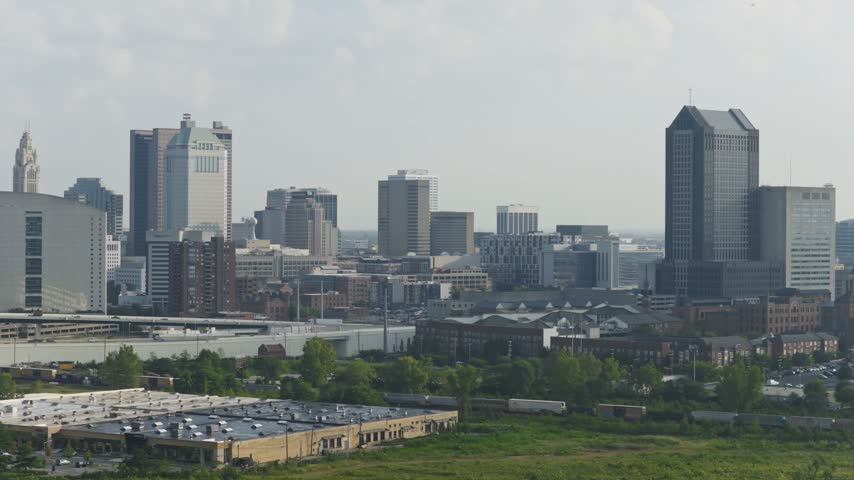 2026 drone video of Columbus OH skyline towers and buildings along new highway i70 east west cas with traffic on roadway by Ohio capital city downtown hub and business district and Audubon center park 4k