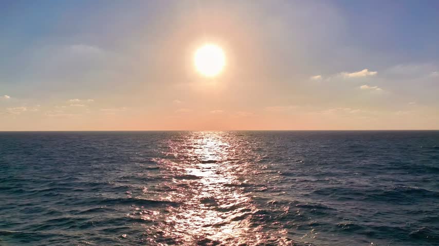 Bright sun shining over the calm Mediterranean Sea with sparkling water reflection and clear open ocean horizon.