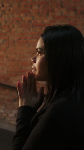 Christian female believer in deep spiritual supplication during evangelical church service expressing heartfelt faith, quiet reverence, and solemn devotion