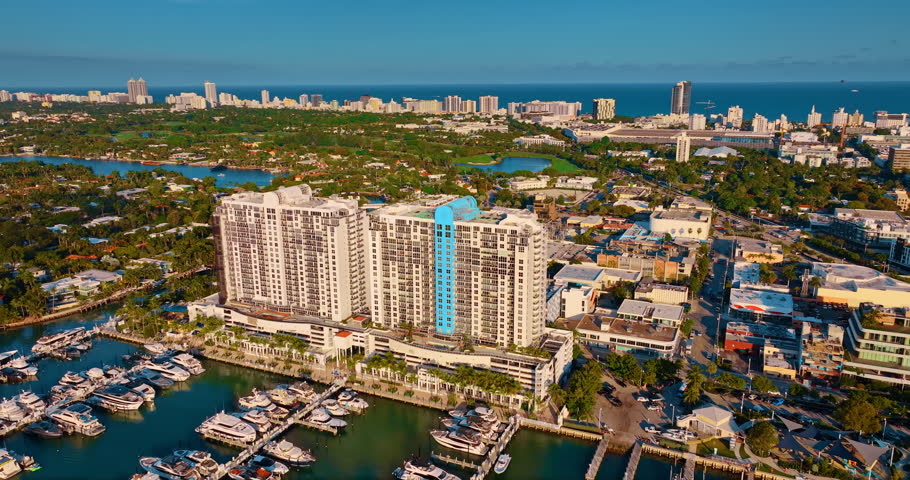 Distancing form the similar high-rise multi-storied buildings built over the water. Berths with numerous modern boats and yachts in front of the buildings. Miami, Florida, USA.