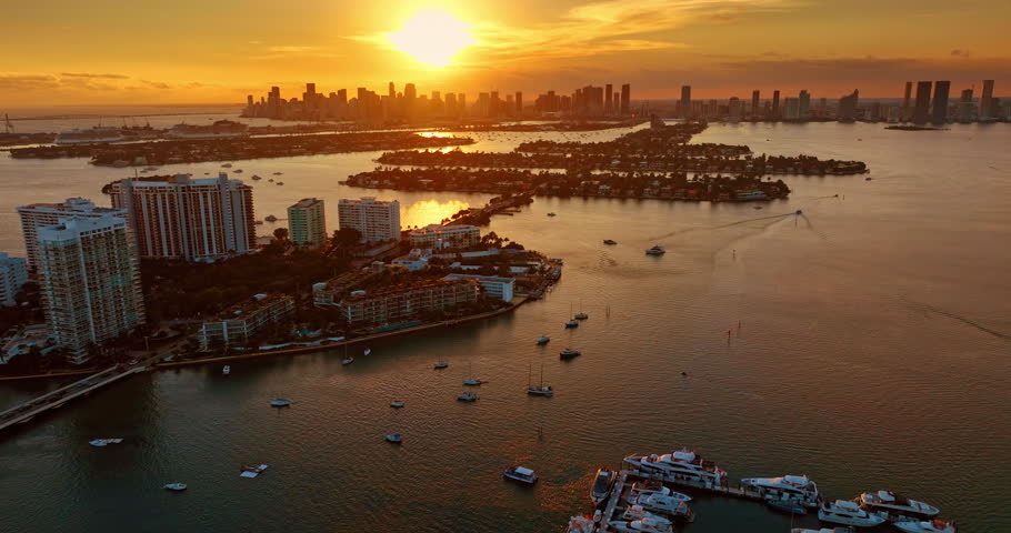 Modern yachts and boats are on the waterscape of Biscayne Bay. Drone over the Brickell Key at sunset. Miami, Florida, USA.