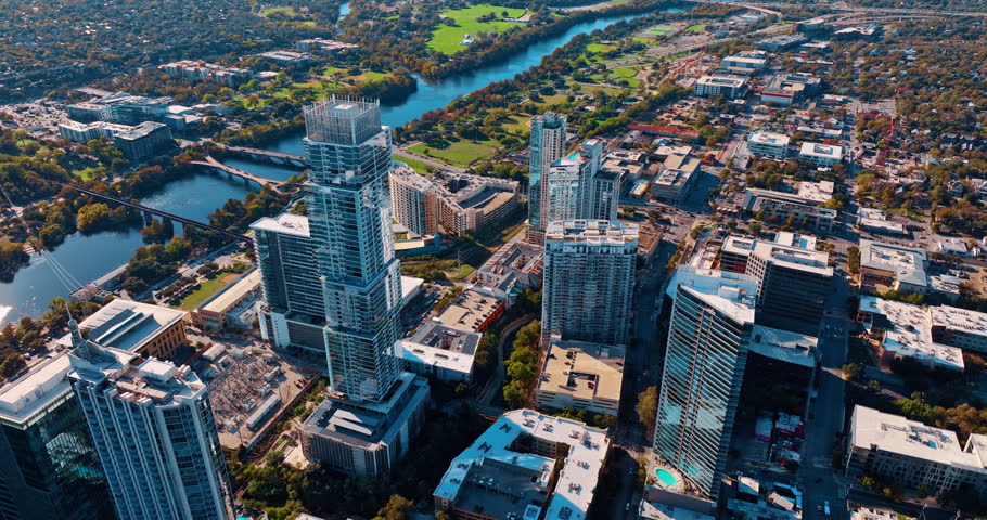 Footage over the picturesque waterfront of the Colorado River with lively traffic on bridges. Sunny cityscape of Houston, Texas, USA.
