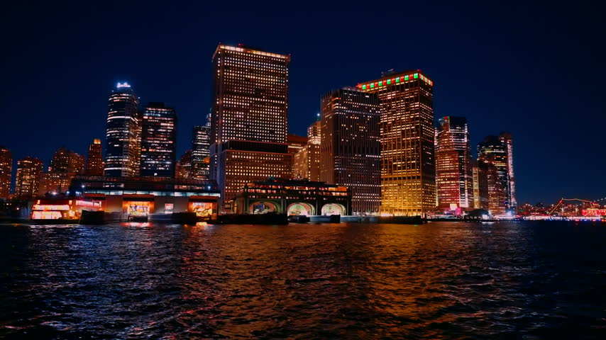Ferry boat terminal in Staten Island, New York, USA. View on the luminous skyline of the city at night from the river.