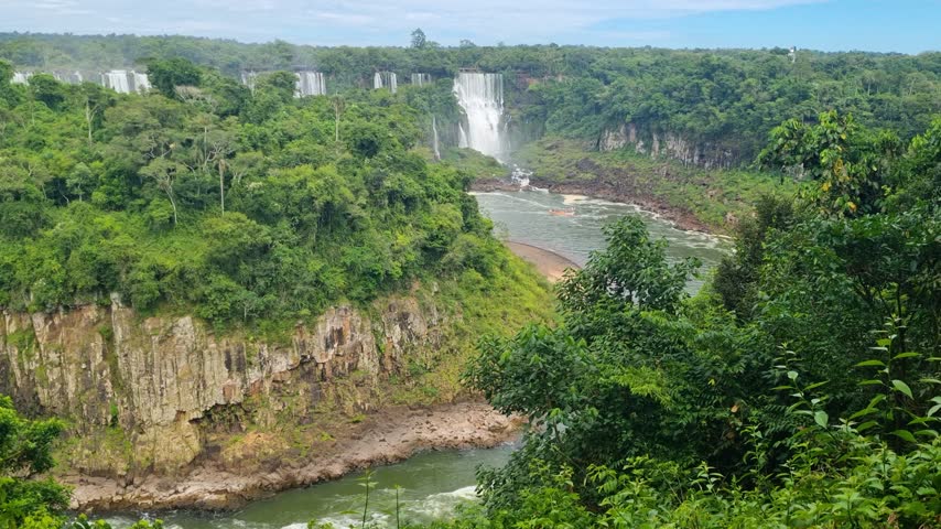 Panoramic view of Iguazú Falls from the Brazilian side, with cascading waterfalls surrounded by lush tropical rainforest near the Argentina border at this iconic attraction