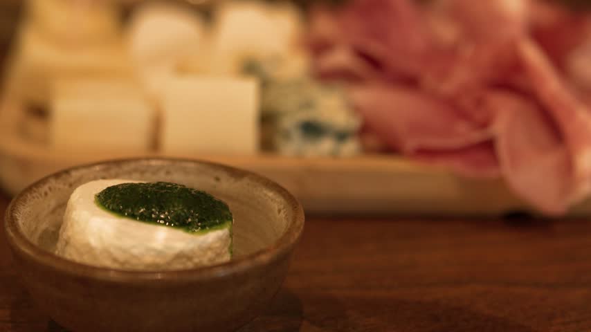 Close-up shot of fresh goat cheese with green herb sauce in Piedmont, Italy.