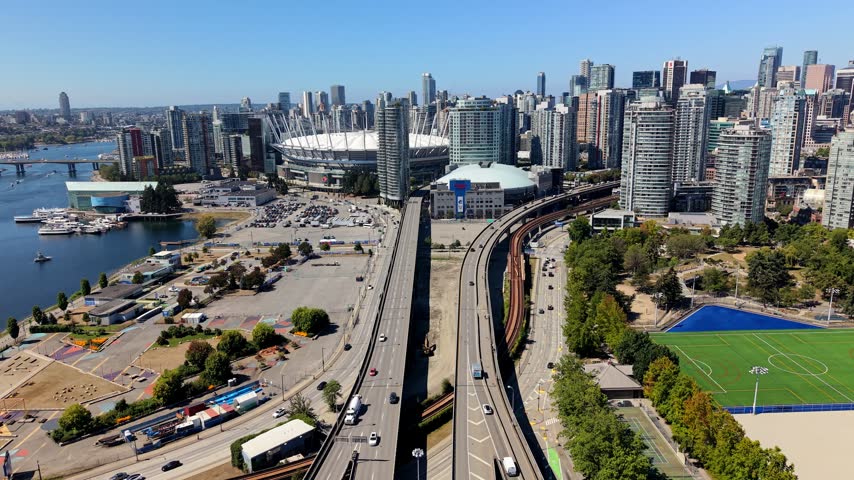 Highways In The Foreground Of Downtown Vancouver With High-rise Buildings, BC Place Stadium And Rogers Arena In BC, Canada. - aerial pullback shot