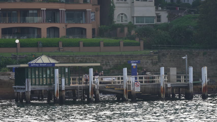 Jeffrey Street ferry wharf viewed across Sydney Harbour, with waterfront residences rising behind the terminal. Sydney, New South Wales, Australia.