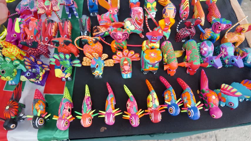 Small colorful alebrije figures displayed at a Mexican artisan stall, showcasing traditional folk art and craftsmanship.