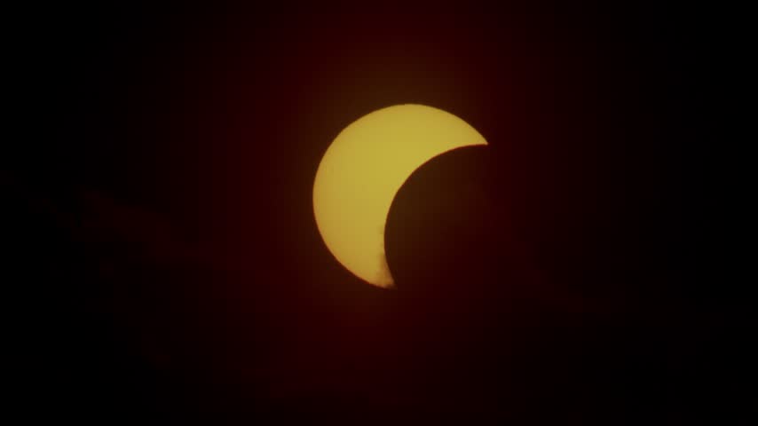 Partial solar eclipse near horizon at sunset time