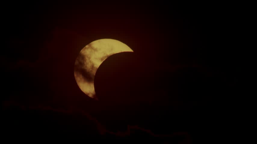 Partial solar eclipse near horizon at sunset time