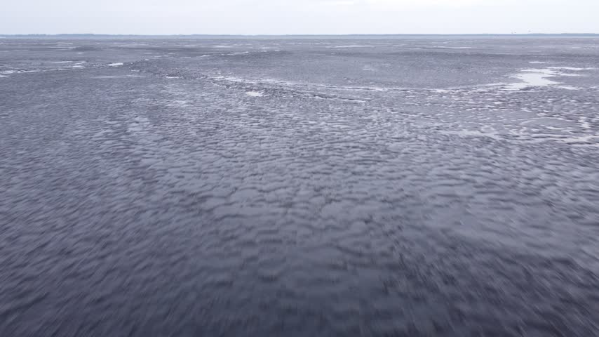 Last brittle and dangerous ice with crack on the lake in the spring.