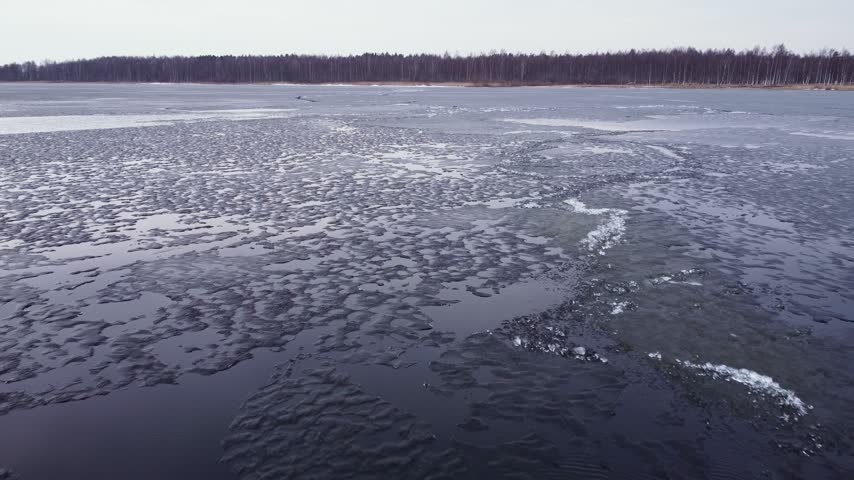Last brittle and dangerous ice with crack on the lake in the spring.