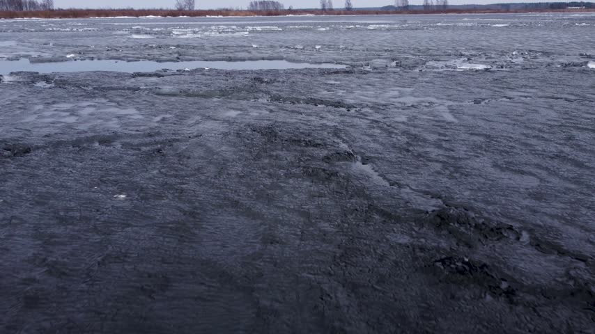 Last brittle and dangerous ice with crack on the lake in the spring.