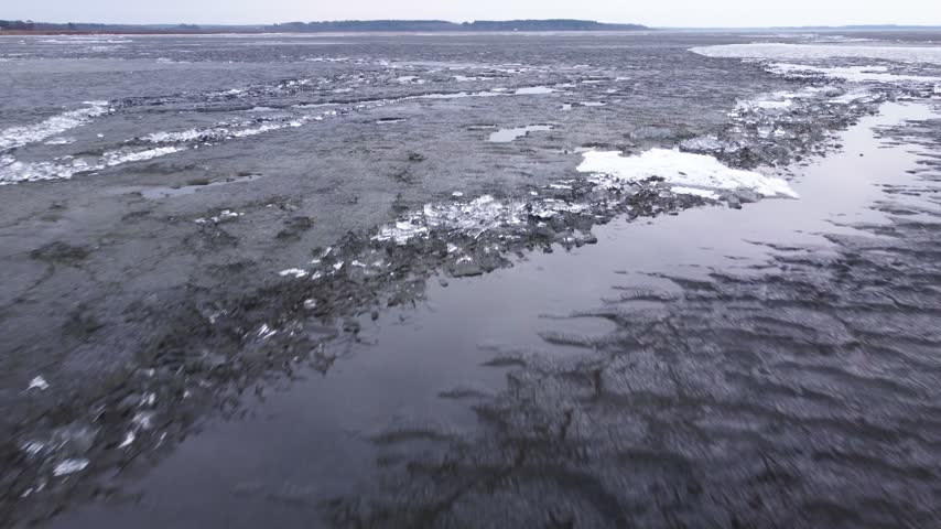 Last brittle and dangerous ice with crack on the lake in the spring.