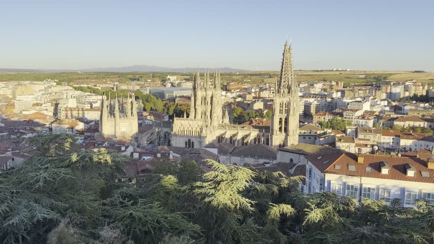 Elevated panoramic view of Burgos Cathedral rising above the historic city of Burgos in warm evening sunlight, Castile and Leon, Spain.