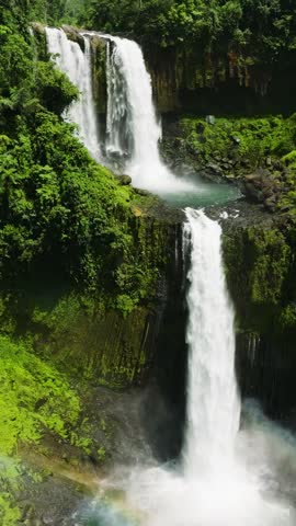 Waterfall with Rainbow Formation in Lush Green Forest Setting