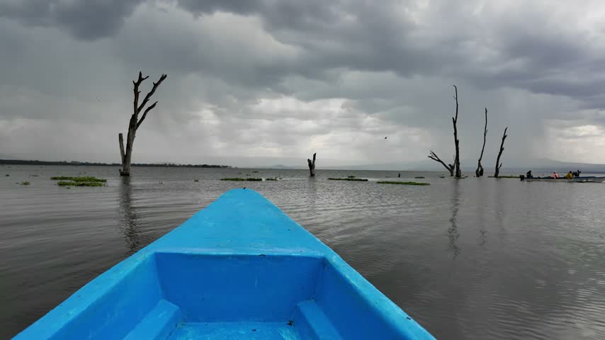 Point of view shot from a boat on a lake in Kenya with a stormy dark sky