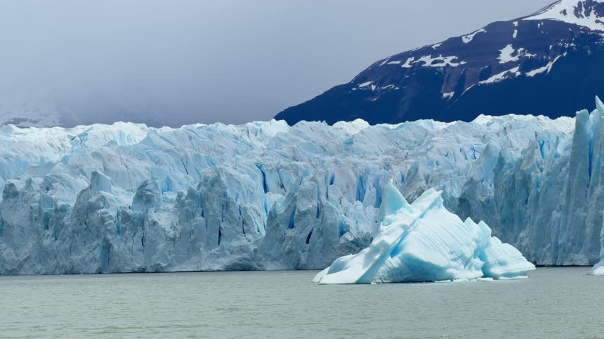 Majestic view of the Perito Moreno Glacier in Patagonia, Argentina. Icebergs floating on the cold water with snowy mountains in the background