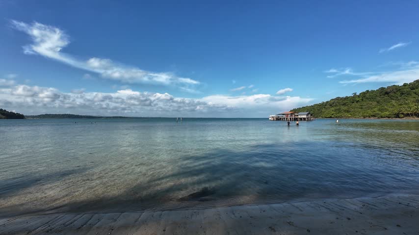 Tropical waterfront with a wooden pier and dramatic clouds over the sea